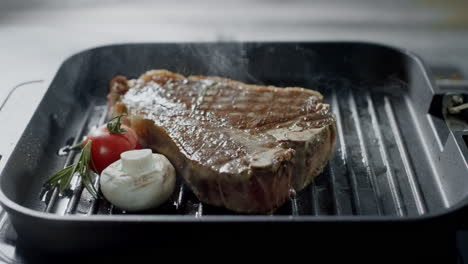 grill meat frying at griddle. closeup steak with vegetables cooking at grill.