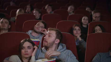 bored audience leaving cinema while session in slow motion. uninteresting film