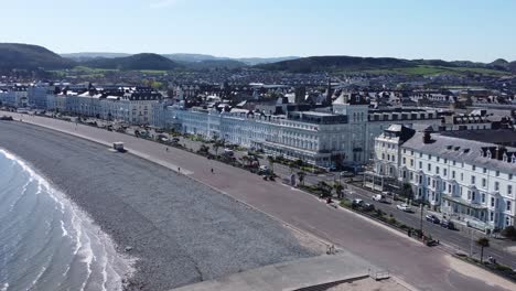 llandudno coastal seaside town hotels on beachfront promenade aerial view descending pull back