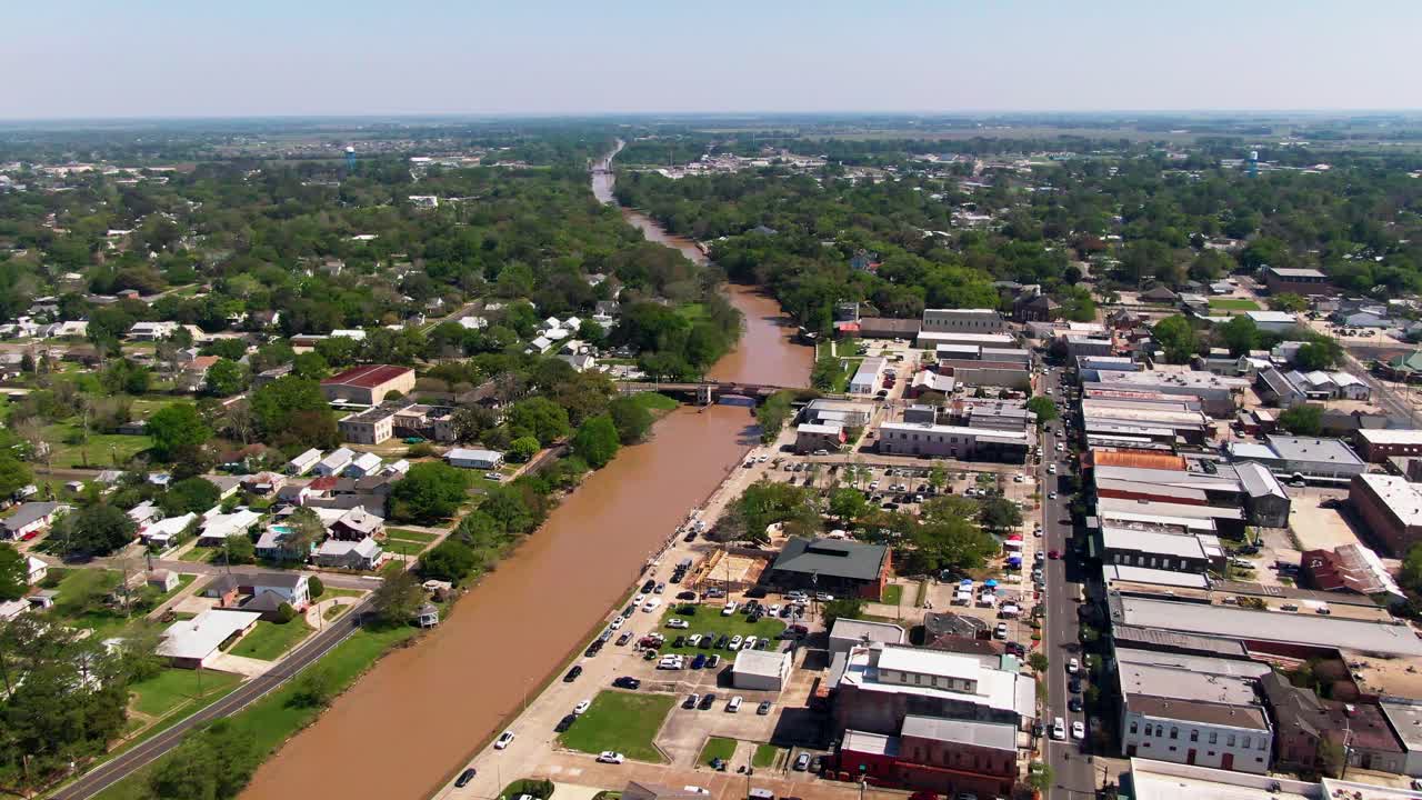 A smooth drone glide over Bayou Teche reveals Bouligny Plaza, tree-lined parks, cozy cafés, and homes stretching toward the horizon of Louisiana’s waterfront towns
