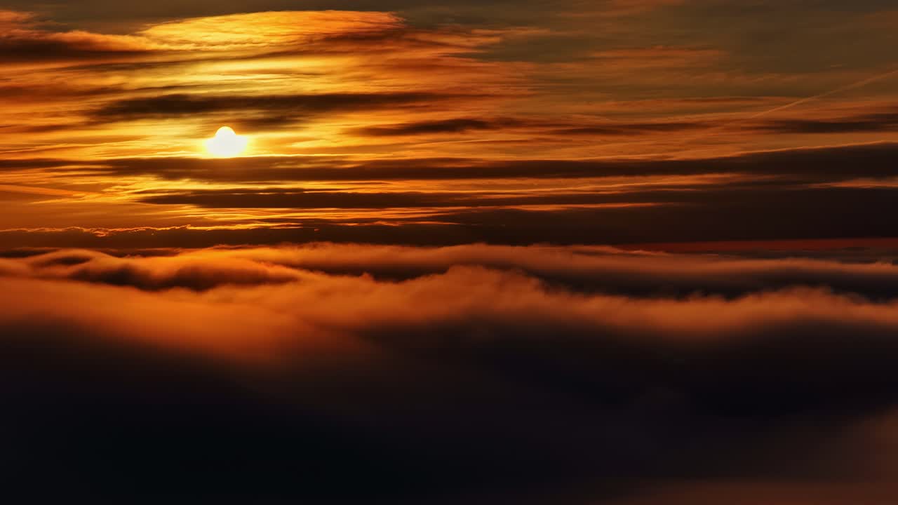 Kinoreifer, goldener Sonnenuntergang über einer dicken Wolkenlandschaft aus der Luftperspektive in der Dämmerung
