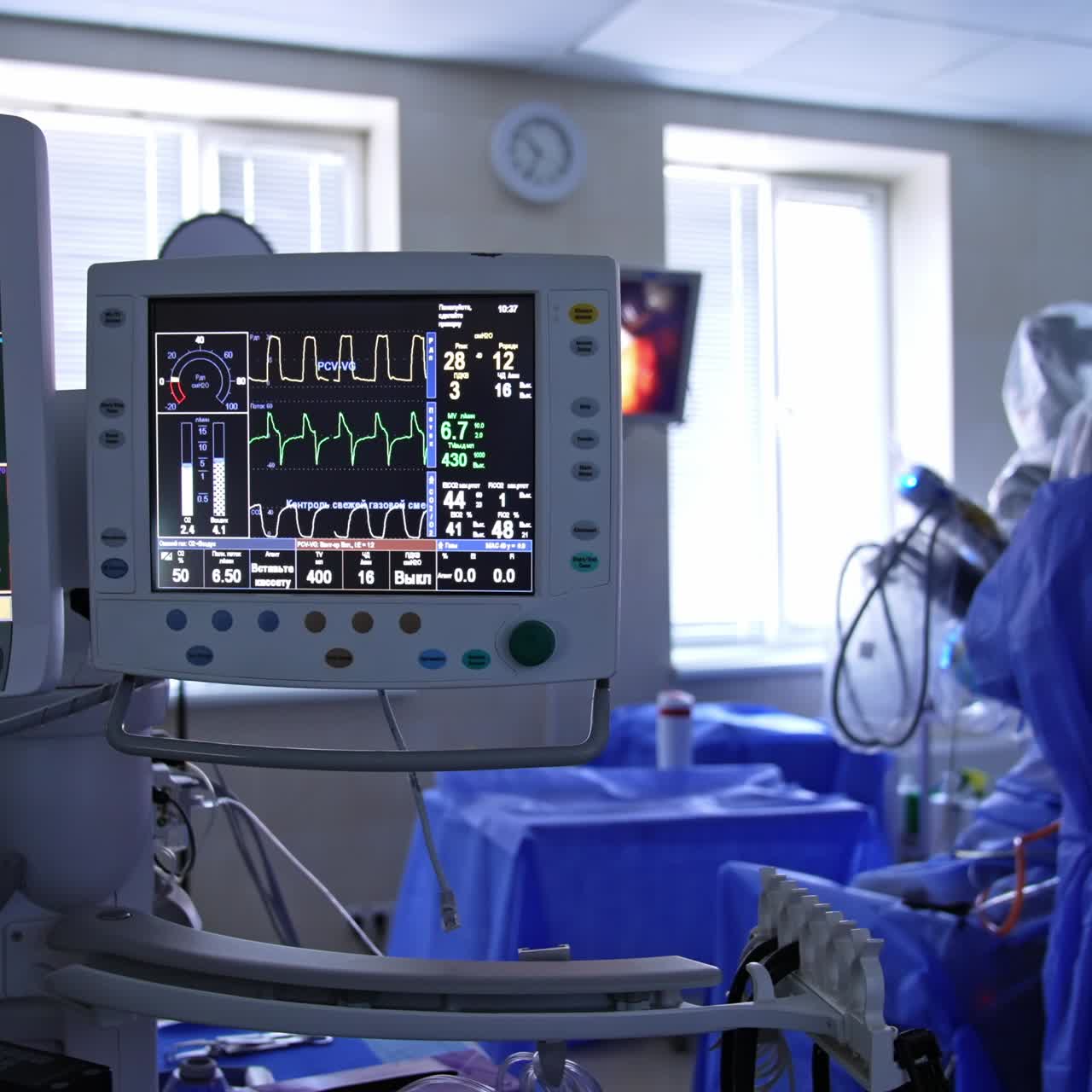 Ventilatore polmonare con due schermi nella sala operatoria durante l'operazione. Un chirurgo robotico esegue la procedura sotto il controllo di un medico.
