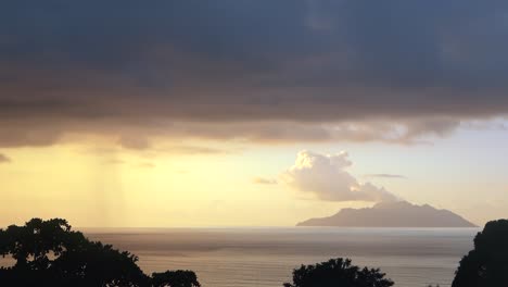 Time-lapse-of-sunset-over-the-Beau-Vallon-beach-on-Mahe,-golden-hour-colour-and-fast-moving-rain-clouds