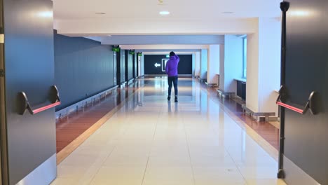 confident man walking in modern corridor in casual style, back view