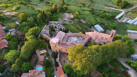 aerial orbit of the fortified cemetery and romanesque church of brihuega, in la alcarria, spain. surrounded by trees and farmland, this clip shows rich textures and historic architecture at sunrise