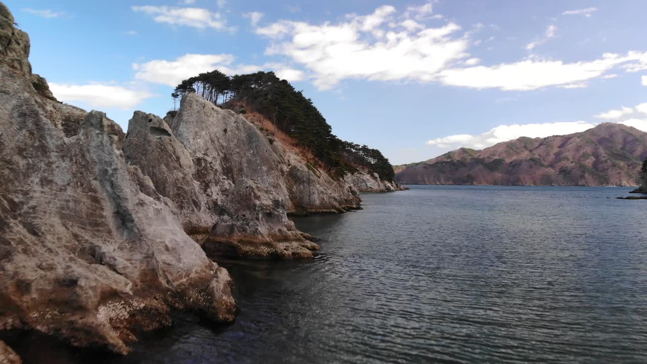 lento vuelo aéreo hacia arriba sobre rocas volcánicas en la playa de jodagahama en japón