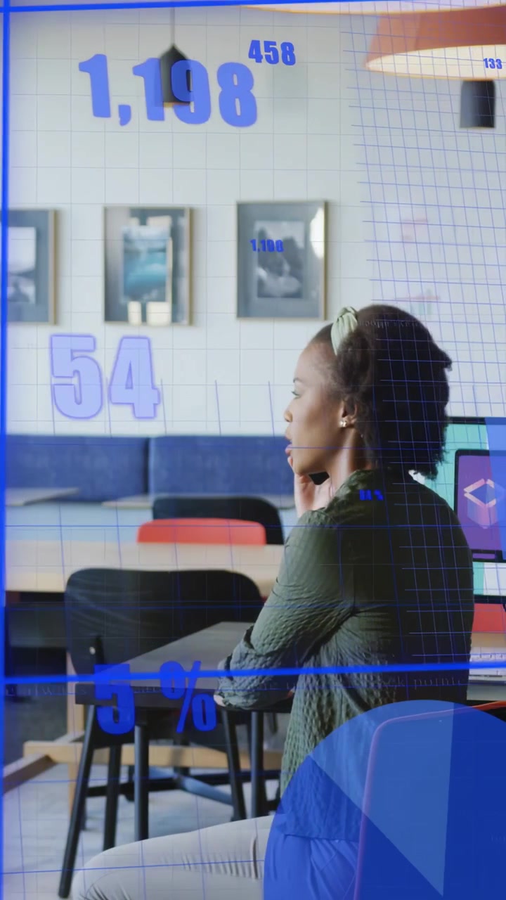 Video verticale: Donna seduta in ufficio, che si gira verso grafici blu che appaiono e analizza dati tecnologici