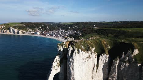 Grandes-Y-Hermosos-Acantilados-De-Tiza-En-La-Costa,-Pequeño-Pueblo-En-La-Costa-Hacia-El-Mar,-Océano-Atlántico,-Drone,-Francia,-Etretat.