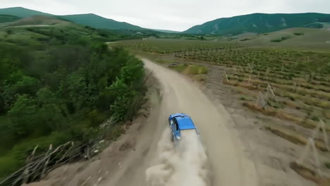 aerial view of rally car driving through vineyard landscape