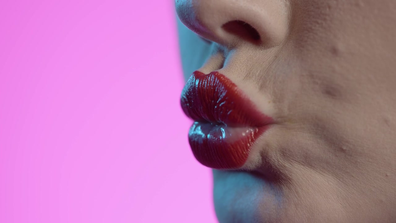 donna che si lecca le labbra, rossetto rosso, sfondo giallo