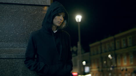 mysterious woman standing city lights wearing hoodie at night street.