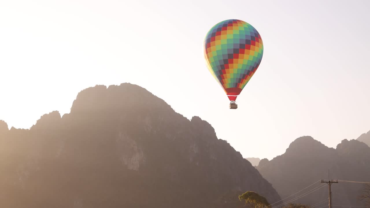 colorful hot air balloon floating by mountain peaks in Vang Vieng, the adventure capital of Laos