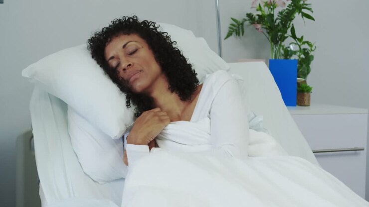 Vista frontal de paciente afro-americana dormindo na cama na enfermaria do hospital 4k