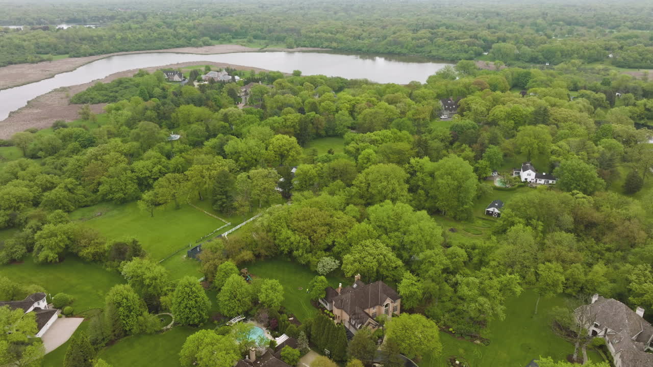 Nice private houses half-hidden in the green trees. Beautiful rural American suburb located at the river bank. top view.