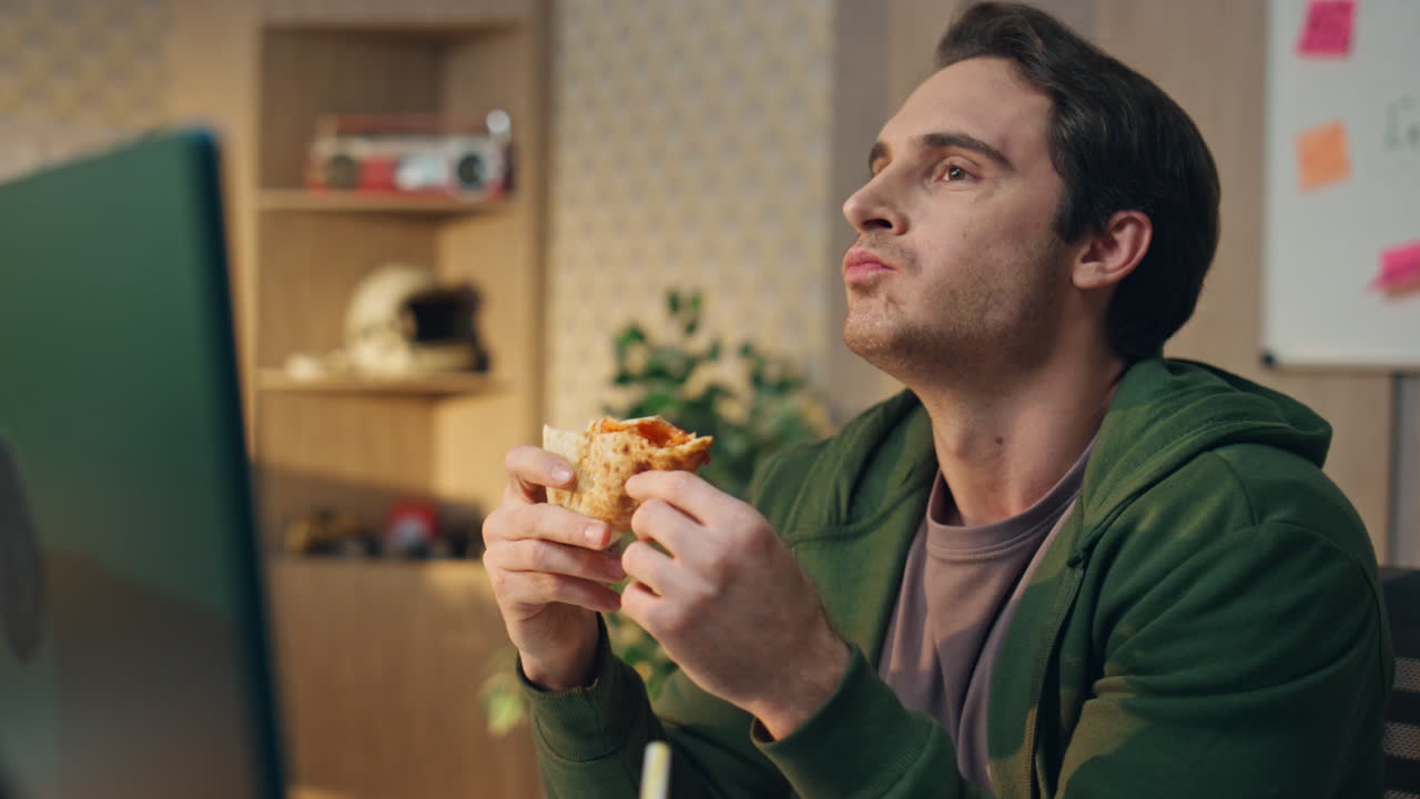 hombre de primer plano tomando pizza almuerzo en la oficina. hablando tipo relajado comiendo comida
