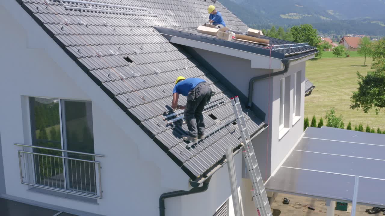 Man working of the edge of the roof installing rails, risky job