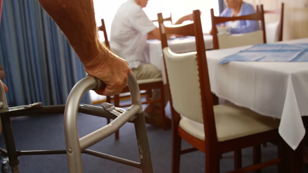 hombre mayor caminando con la ayuda de un marco para caminar