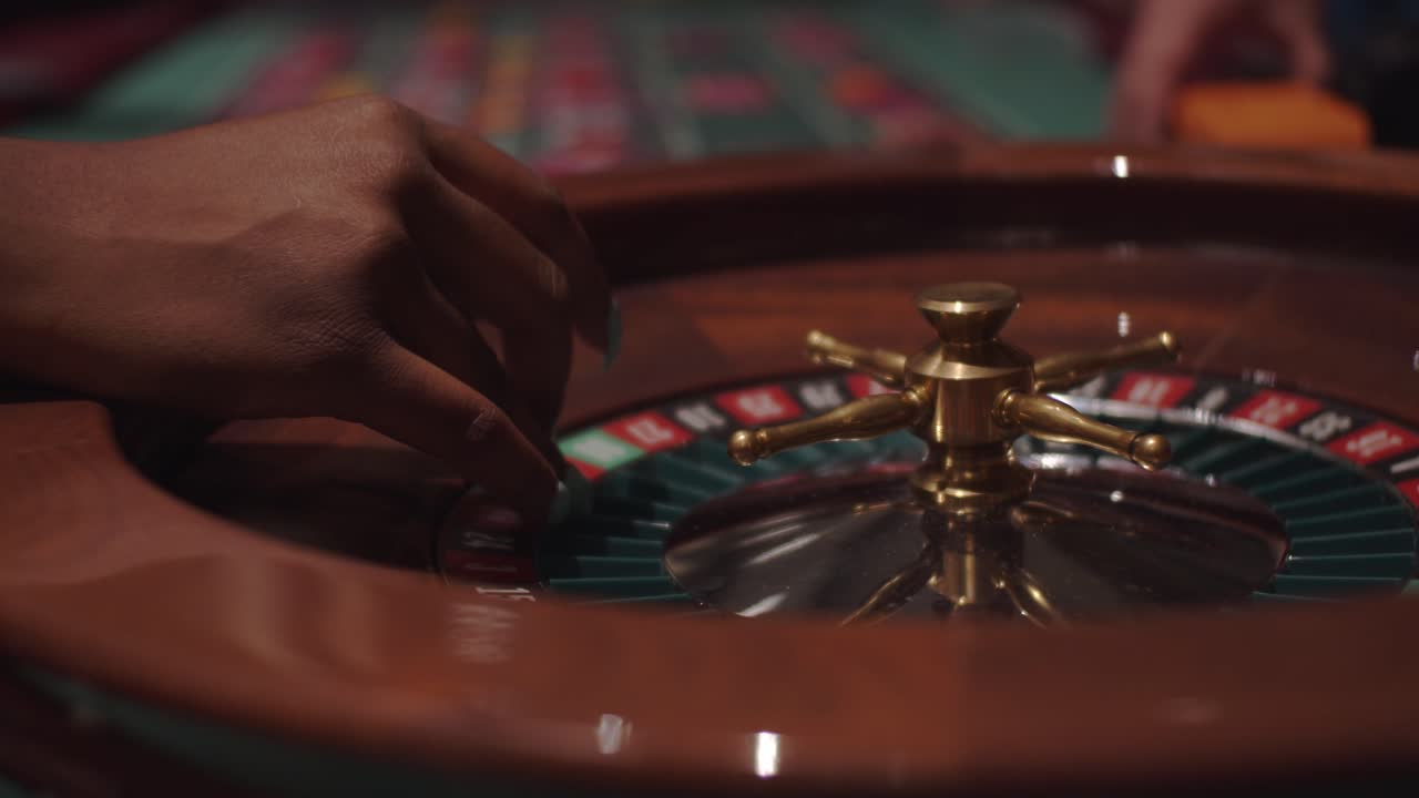 Black woman female spinning roulette wheel at casino party in slow motion