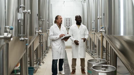 two men talking in a factory