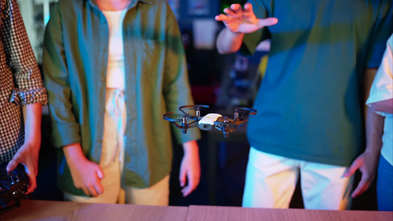 Young engineers with VR virtual reality headset controlling fliying drone in research laboratory, slow motion