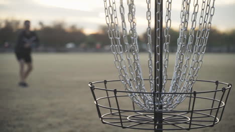 Discgolfspieler-Bläst-Den-Korb-Auf-Seinem-Putt-Mit-Luftbällen-Und-Versucht,-Ihn-In-Den-Übungs-Discgolfkorb-Zu-Verwandeln