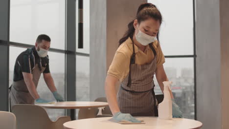 cafe workers disinfecting tables before opening