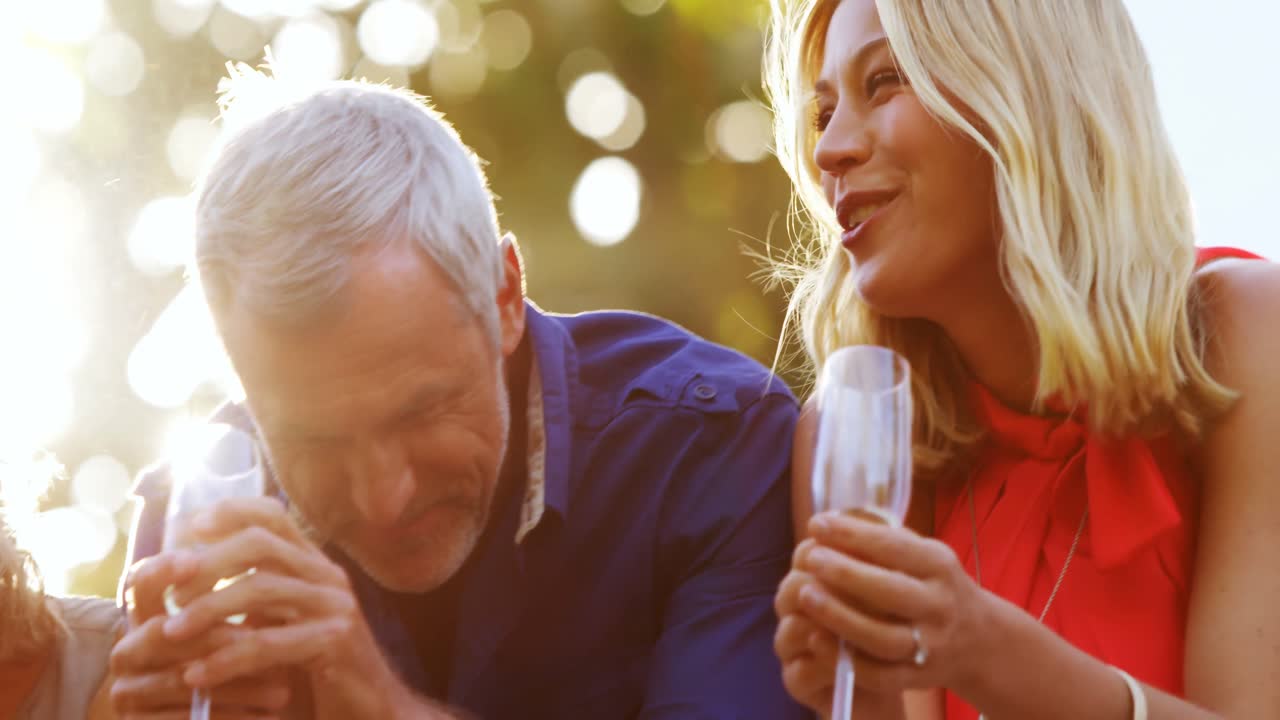 친구 들 이 발코니 에서  ⁇ 페인 을 마시면서 서로 대화 하고 있다