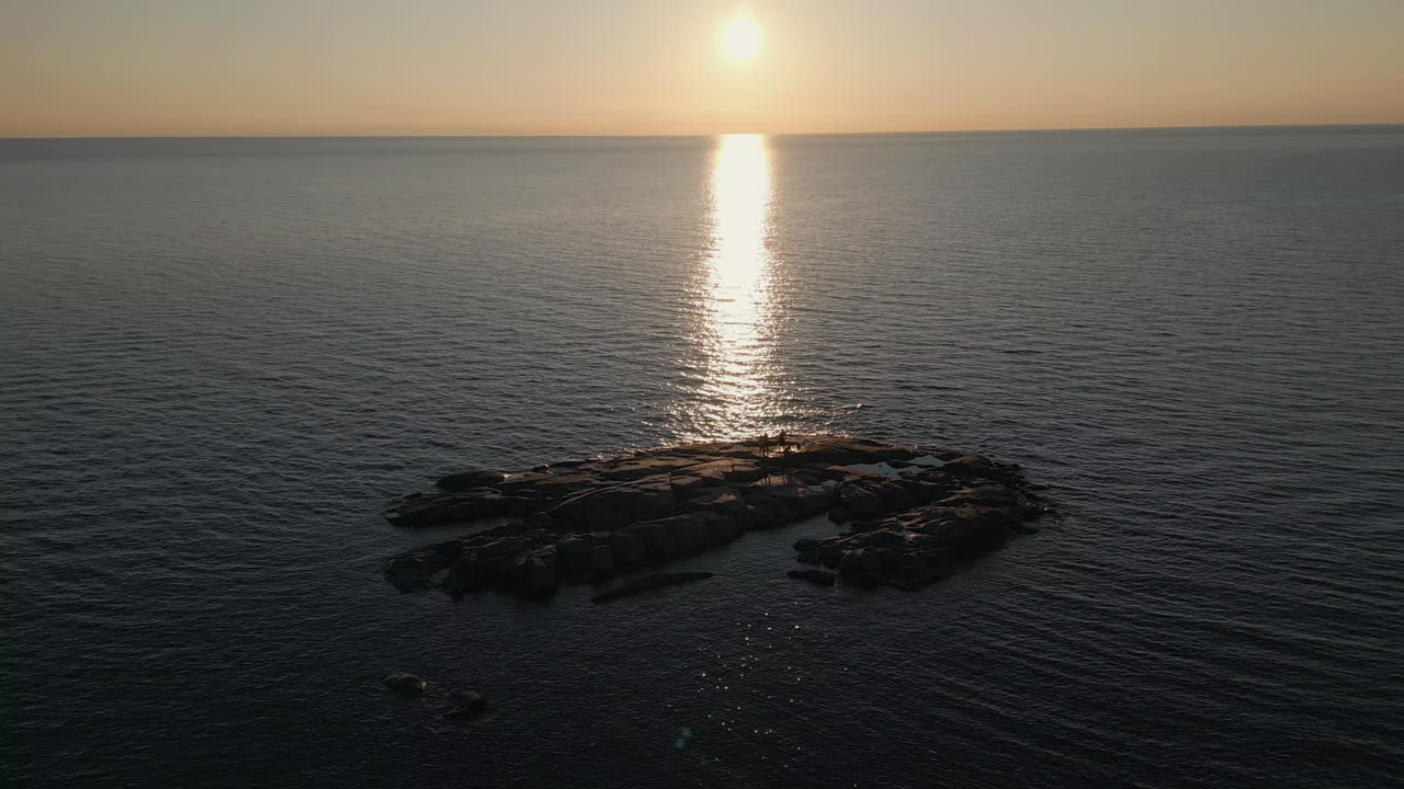 해가 지는 섬에서 혼자 서 있는 친구들의 그룹