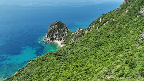 Exuberantes-Acantilados-Verdes-Con-Vistas-A-Las-Cristalinas-Aguas-Azules-Del-Mar-Jónico-En-La-Isla-De-Corfú,-Grecia,-Vista-Aérea