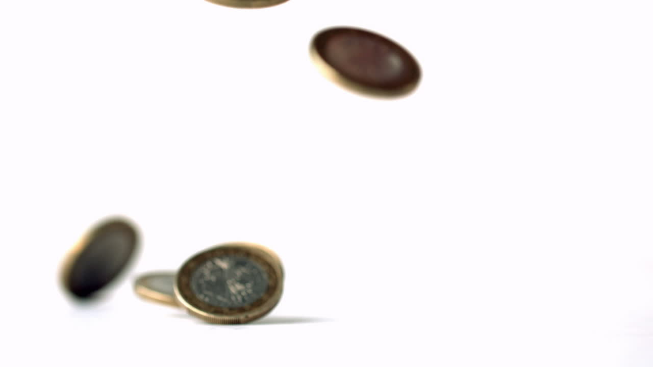 monedas de euro que caen sobre una superficie blanca