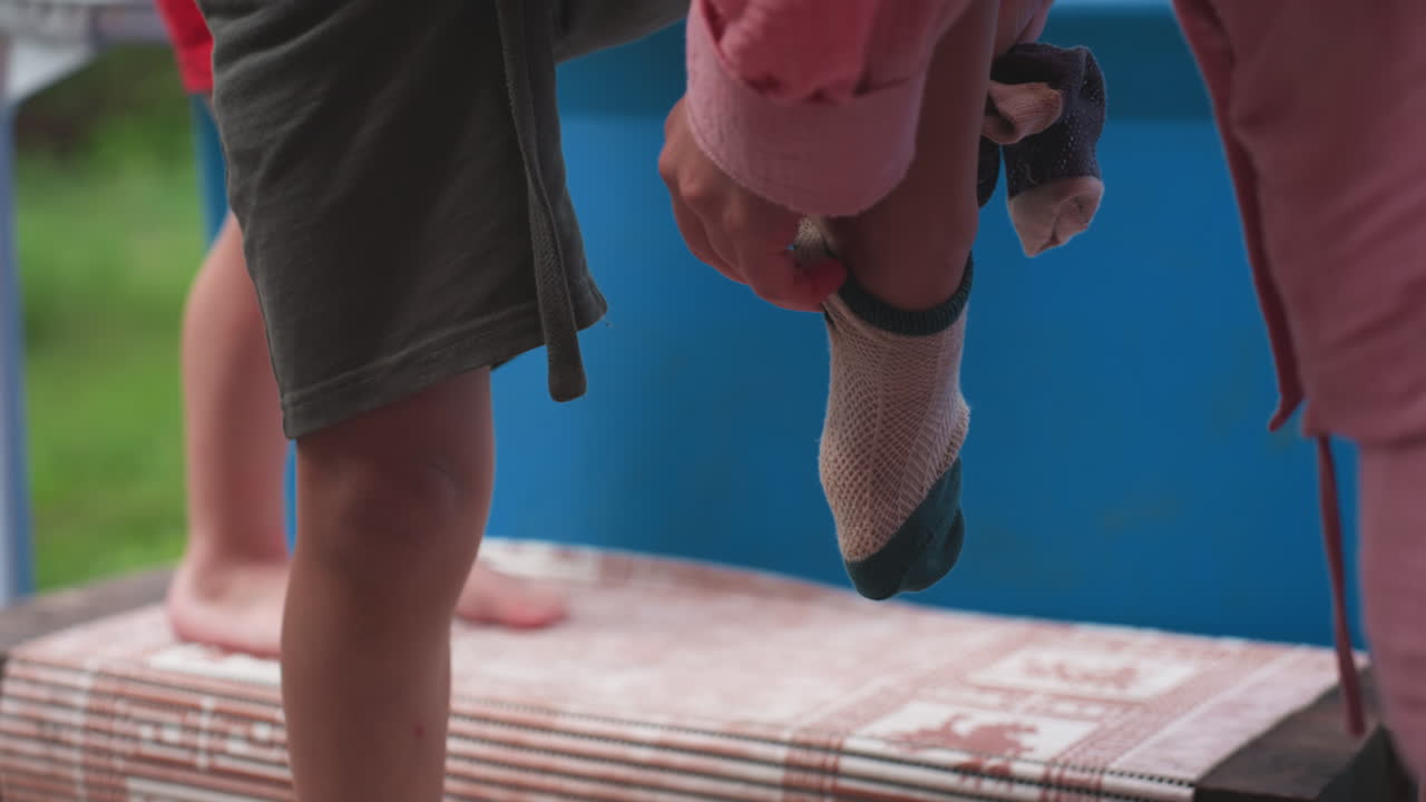Child Stepping Down With Stuffed Toy In Hand, Cautious Movement On Wooden Platform, Closeup Of Small Legs And Grip, Backyard Transition From Play Area To Ground, Quiet Exploration And Protection