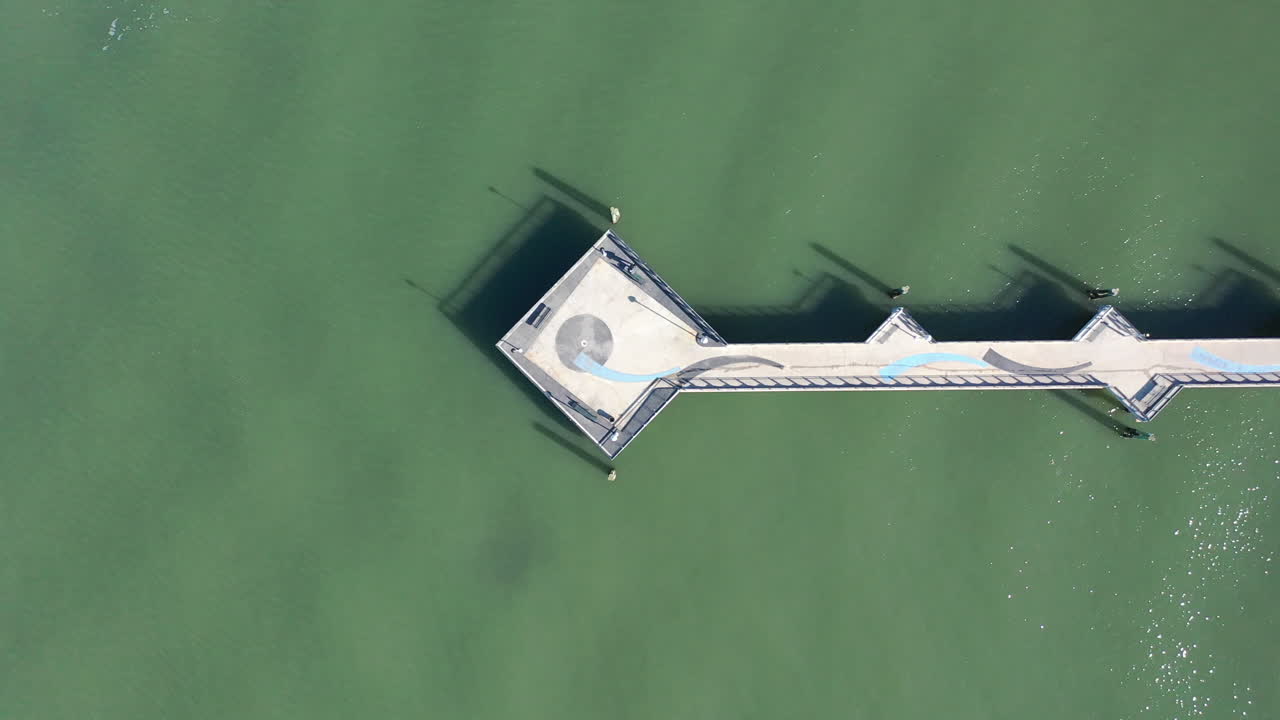 화창한 날 빨간 갈고리 수로에 있는 녹색 물 부두 위의 하향식 샷