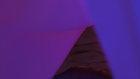 close-up slow-motion shot of a man with clasped hands inside a tent with bright lights