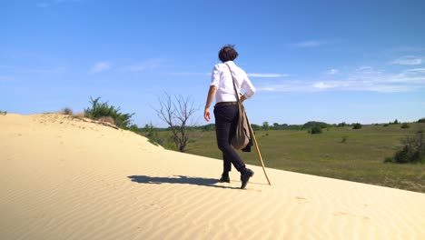 actor playing hungarian poet sandor petofi walks on top of sand dune with staff