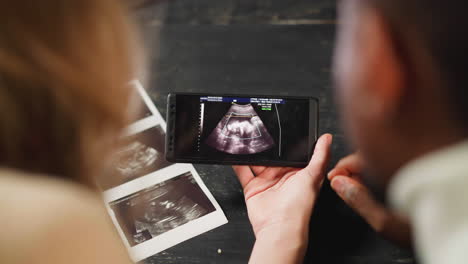 Woman-with-black-partner-watches-baby-ultrasound-record