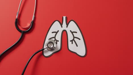 video of close up of stethoscope with lungs on pink background