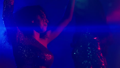 cerca de dos mujeres en un bar de club nocturno o discoteca bailando con luces brillantes 23