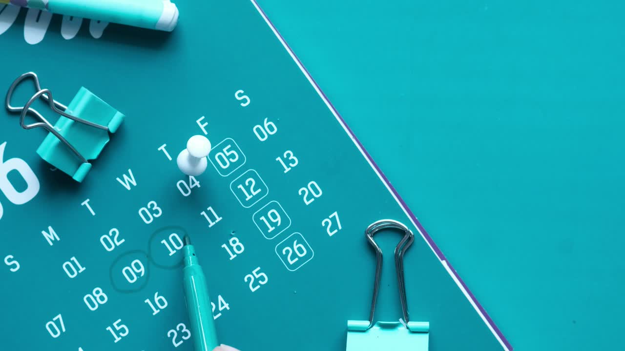 마커와 바인더 클립을 가진 푸른색 달력