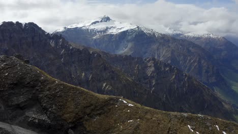 una hermosa cresta con vistas a enormes montañas y un valle verde con un río que atraviesa nueva zelanda en un día soleado