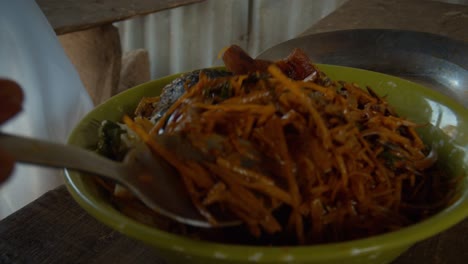 A-close-up-shot-of-a-plate-of-African-salad,-abacha-being-turned-with-a-spoon