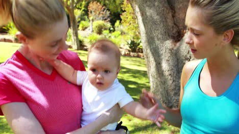 woman holding her baby and interacting with friend