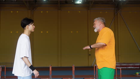 senior and young man talking indoors