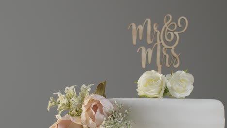 close up of wedding cake on stand against grey studio background at wedding reception 5