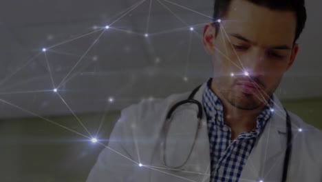 Animation-of-glowing-network-of-connections-over-caucasian-male-doctor-reading-reports-at-hospital