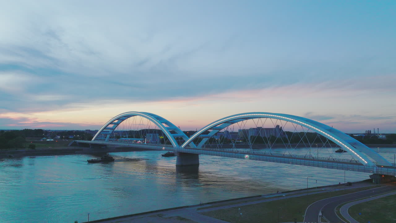 해가 지는 동안 강 을 가로지르는 현대적 인 다리