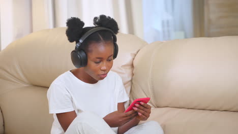 woman relaxing on couch with headphones and phone