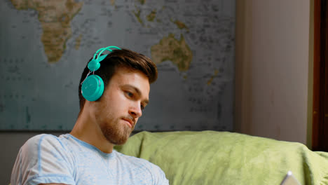 man listening music on digital tablet at home 4k