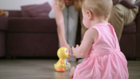 Infant-playing-with-toy-on-floor.-Sweet-baby-enjoy-walking-in-room