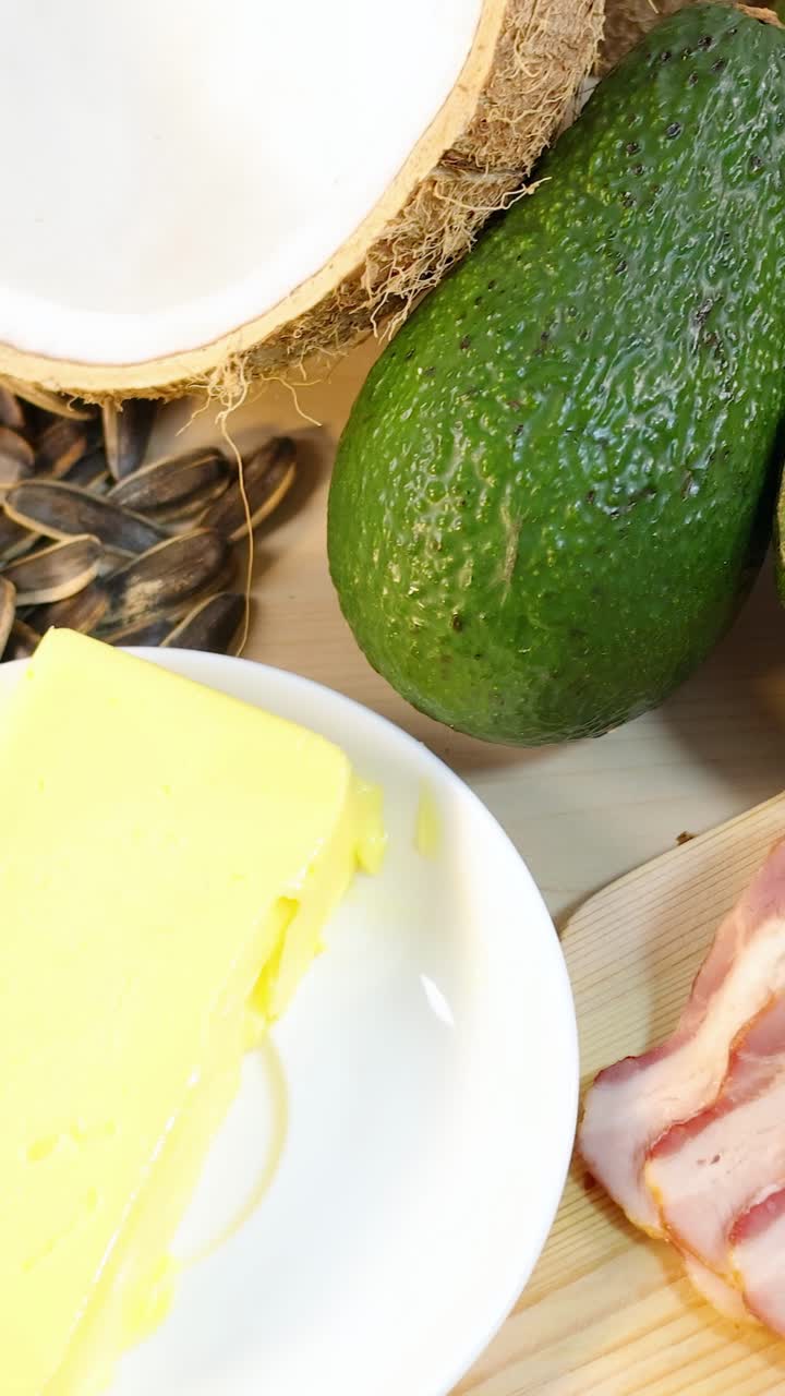 Berbagai jenis lemak sehat termasuk kacang-kacangan, biji-bijian, dan minyak tertata di permukaan kayu di bawah pencahayaan terang