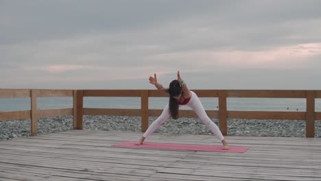 woman practicing yoga outdoors on a beach